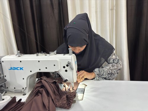 A trainee stitches a school uniform at the Sabaat Centre.